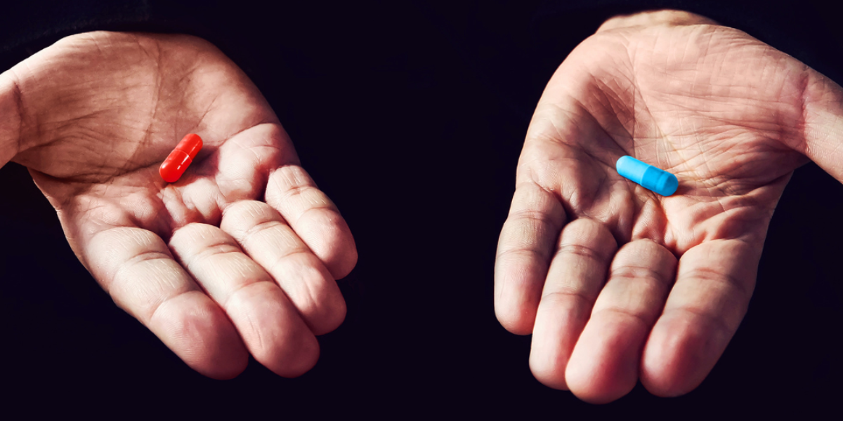 Hands holding a blue pill and a red pill - the Matrix